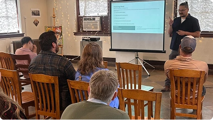 Facilitator presenting financial concepts on a screen to a group of business owners